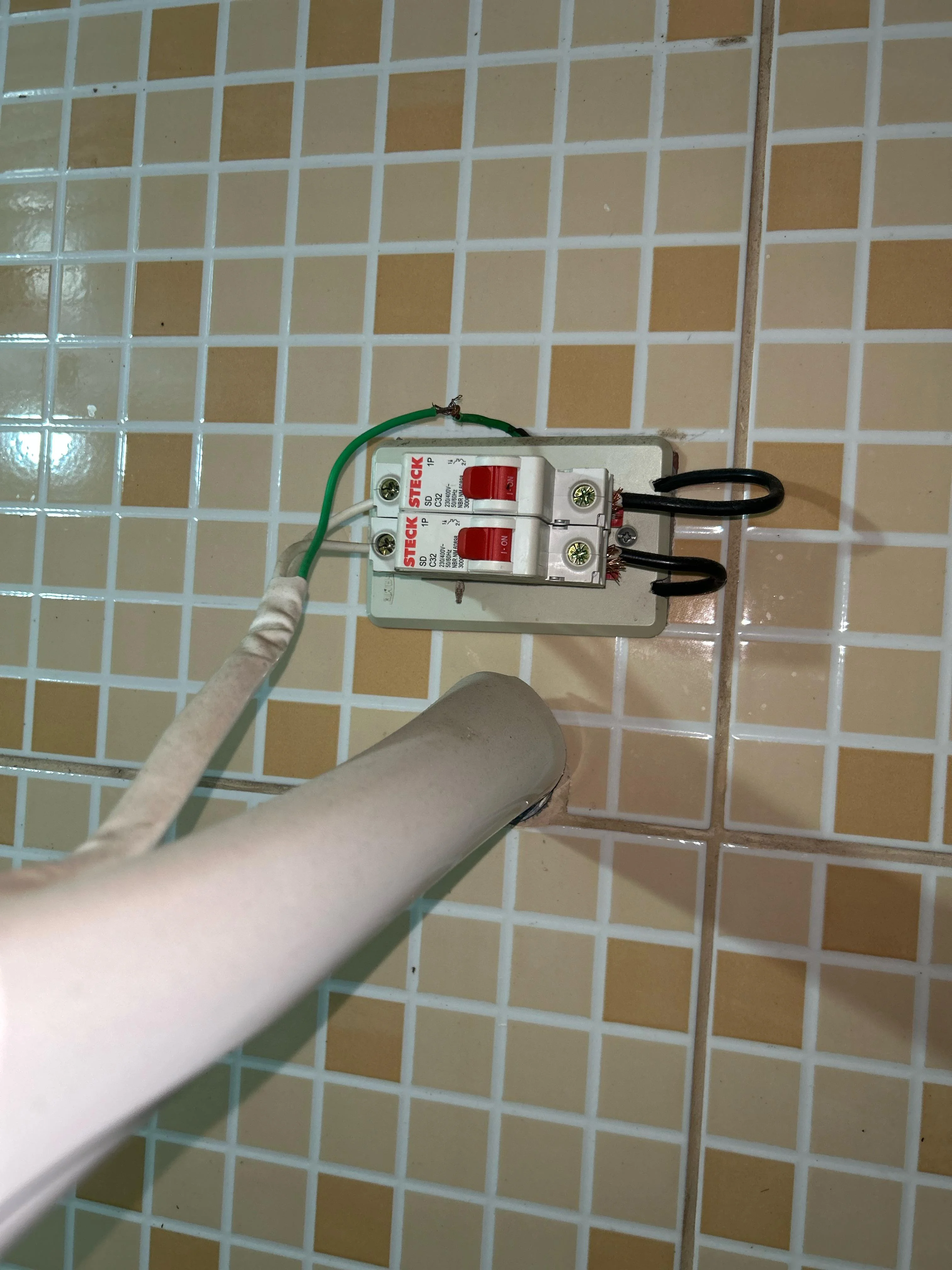 Exemplo de instalação elétrica insegura: chuveiro ligado em tomada comum sem circuito adequado